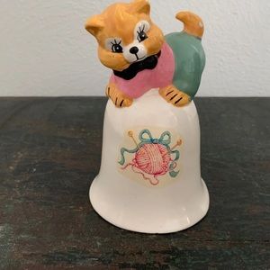 Vintage ceramic bell bow tie wearing cat and a ball of yarn
